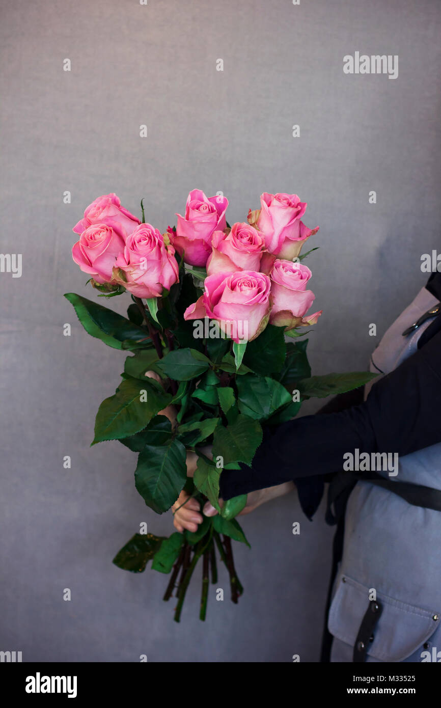 Young woman florist holding big bouquet of pink roses Stock Photo - Alamy