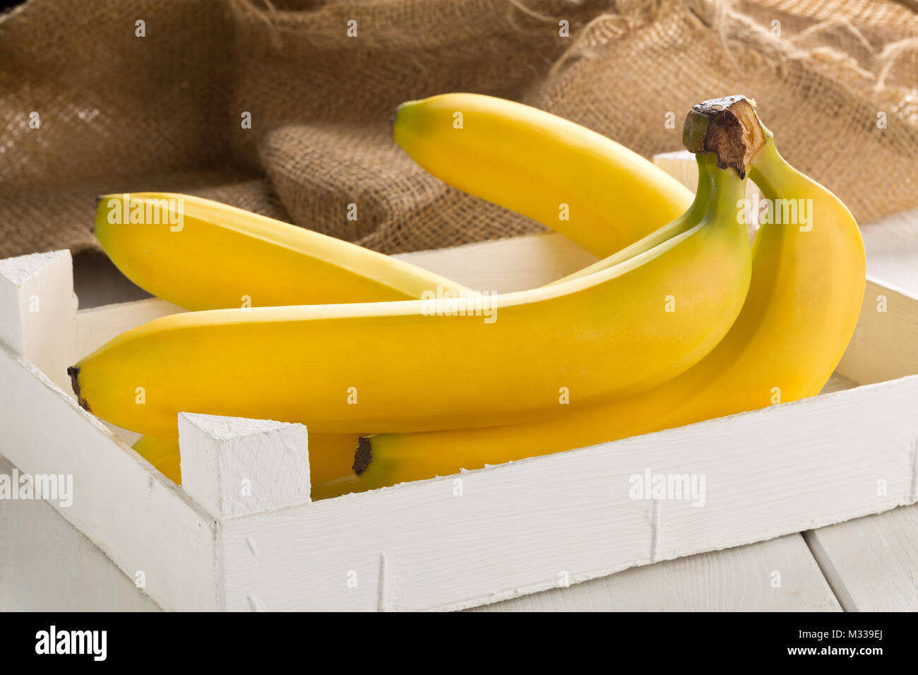 Banana Ripe Pack Bundle of fresh, yellow, ripe bananas in white wooden box on wood table ...