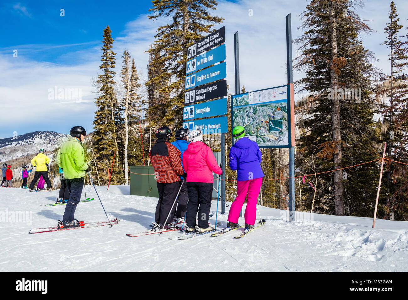 Colorfully dressed downhill skiers looking at the Trail Map of the Steamboat Ski Resort, Colorado;  on a nice winter day; two skiers are overweight Stock Photo