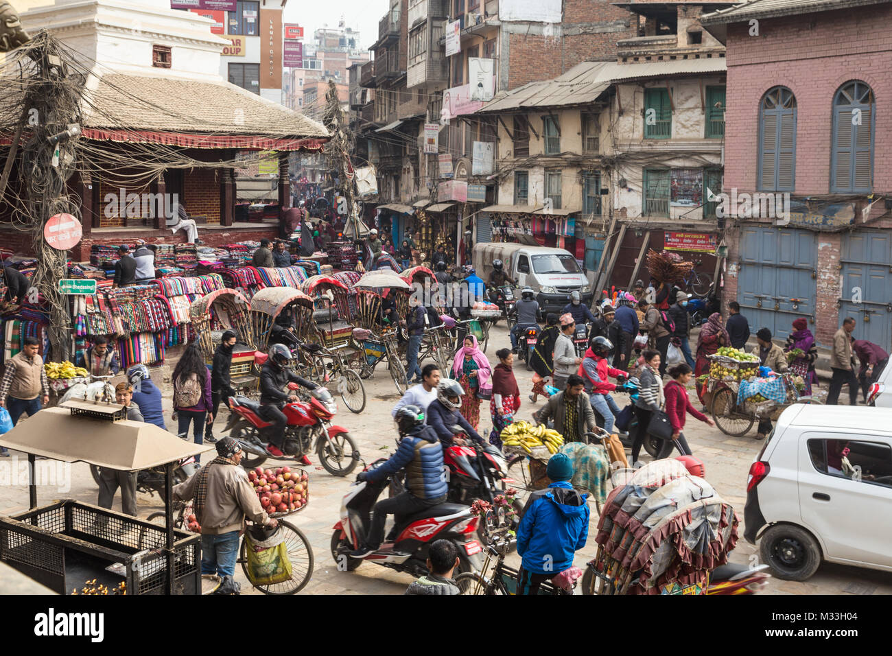 Kathmandu, Nepal - December 20 2017: Traffic of cars, rickshaws and people move in the chaotic streets of Kathmandu at the Indra Chowk intersection in Stock Photo