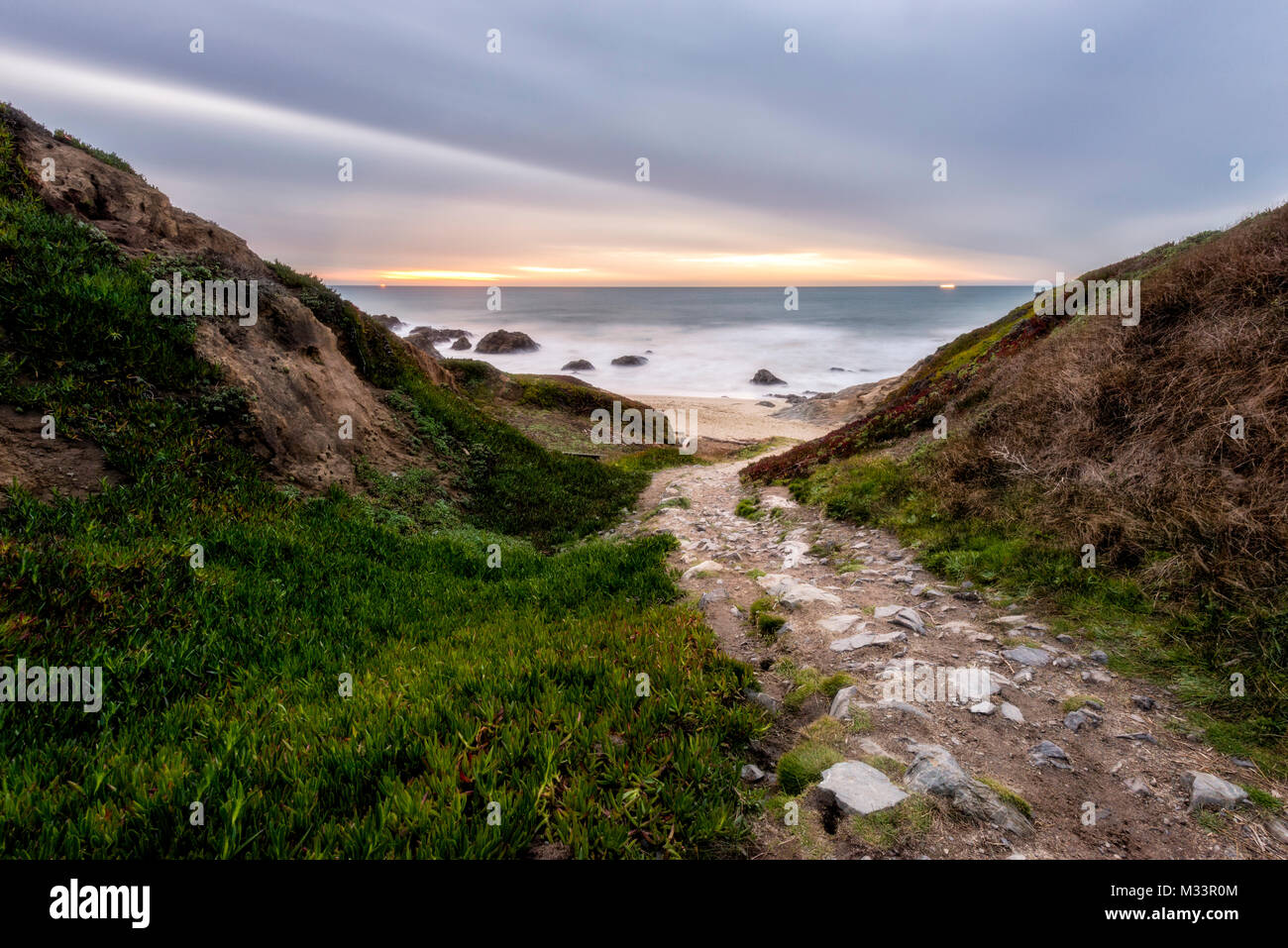 A rocky path leads down to the beach at Bodega Head near Bodega Bay at sunset, California. Stock Photo