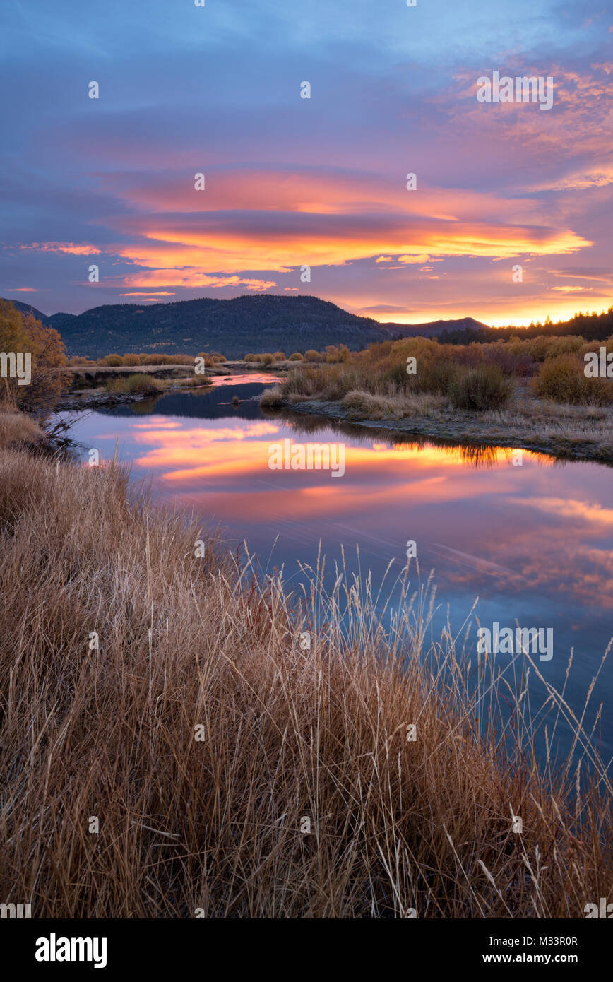 A beautiful sunrise reflects in the West Fork Carson River in the fall in Hope Valley, California. Stock Photo