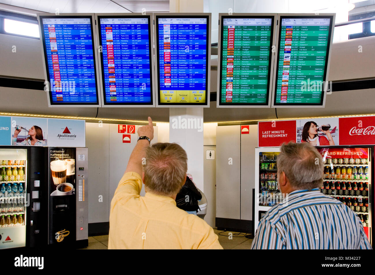 Passagier zeigt mit der Hand zur Hinweistafel auf dem Flughafen TXL Berlin Tegel Stock Photo