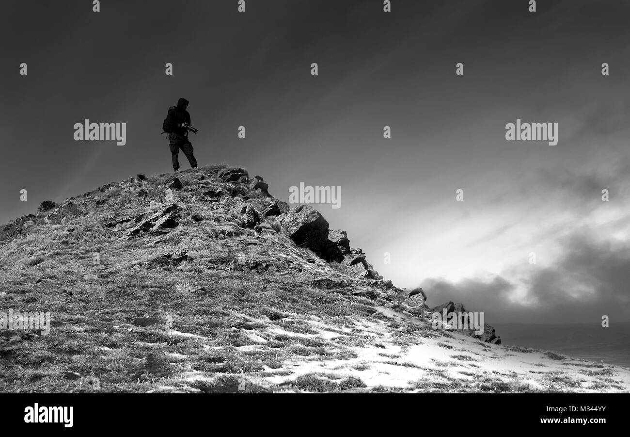 black and white landscape with one photographer on the top in winter mountain Stock Photo
