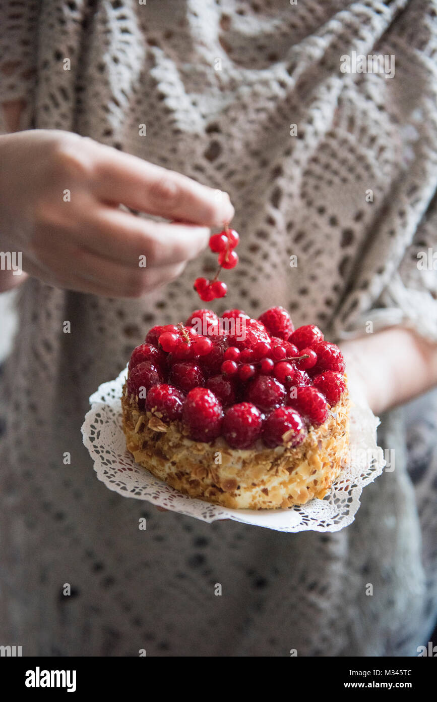 Woman holding a raspberry and redcurrant cake Stock Photo - Alamy