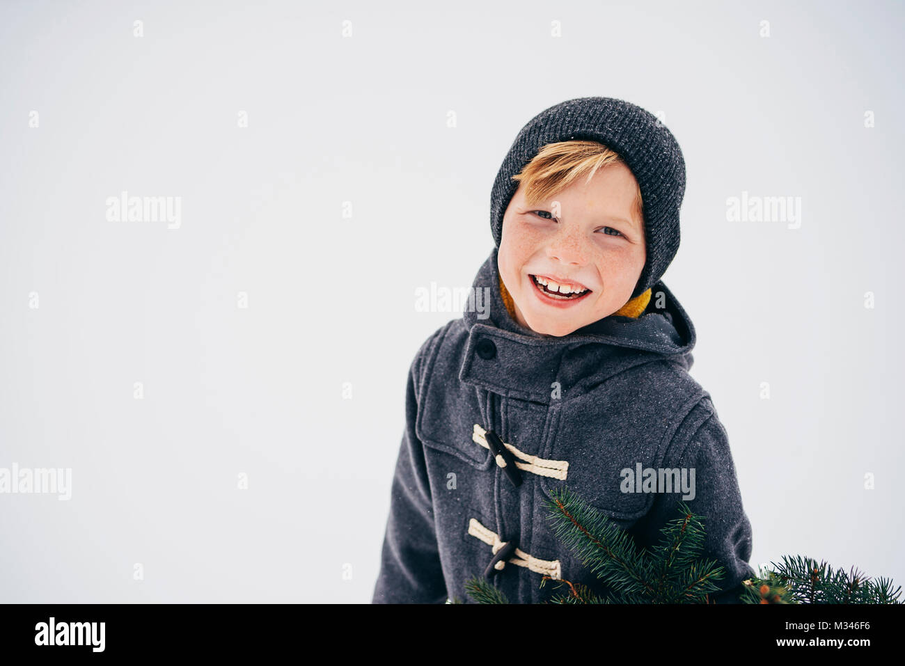 Portrait of a smiling boy standing in snow Stock Photo