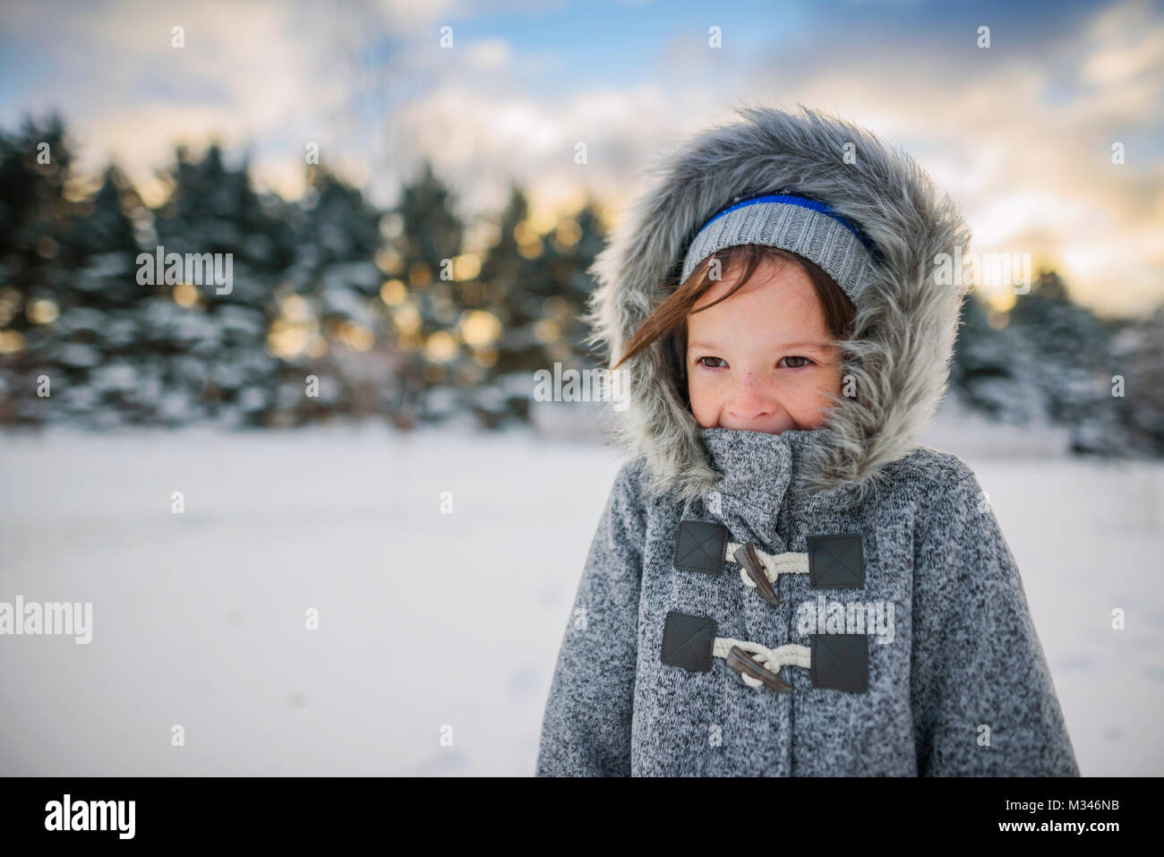 Portrait of a smiling girl standing in snow wearing a warm coat Stock ...