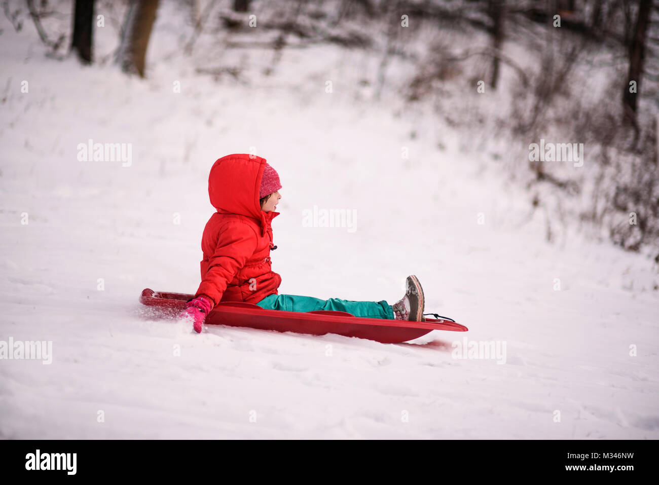 Girl sledging down a hill Stock Photo