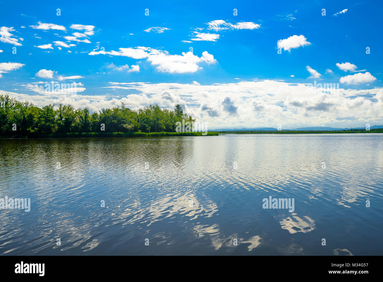 Wide angle lake landscape with trees, forest and clouds in the ...