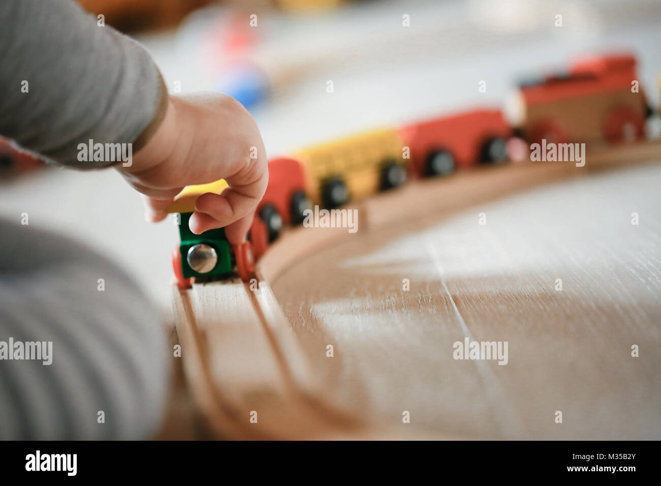 Child playing with wooden train toys. Educational and natural toys
