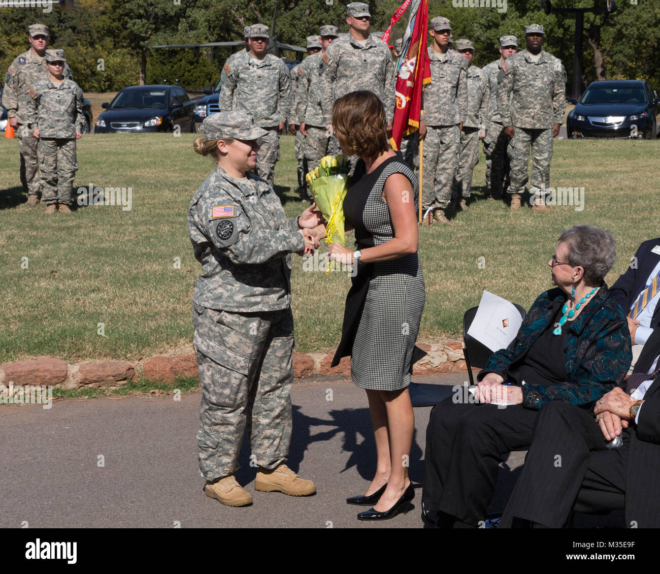 Flowers are presented to Mrs. Zenker, wife of commander, Col