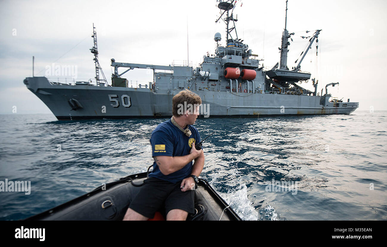 151020-N-CW570-0049 BANTEN BAY (Oct. 20, 2015) Hospital Corpsman 1st Class Jeremiah Sawyer, assigned to Explosive Ordnance Disposal Mobile Unit 11, Mobile Diving Salvage (MDS) 11-7, guides a rigid-hull inflatable boat (RHIB) to USNS Safeguard (T-ARS 50) during dive operations held in support of search and survey operations of the sunken World War II navy vessels USS Houston (CA 30) and HMAS Perth (D29). The data collected by the dive exercise will help the U.S. embassy in Indonesia and Naval Historical Heritage Command catalog the current state of the wrecks. (U.S. Navy photo by Mass Communica Stock Photo