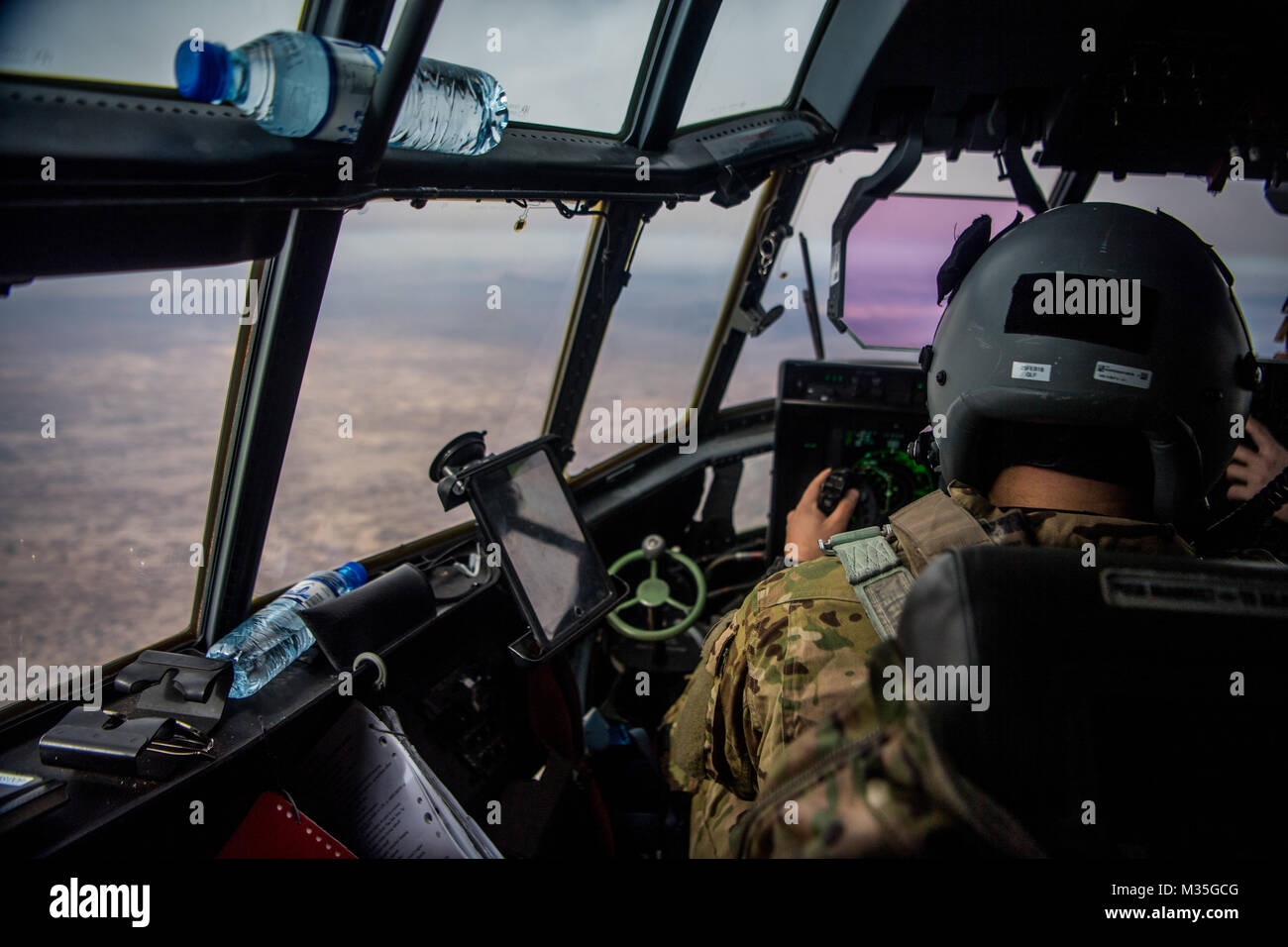 A U.S. Air Force C-130J Super Hercules pilot from the 774th Expeditionary Airlift Squadron flies a mission over Afghanistan to transport passengers and supplies to various bases throughout the country, Feb. 6, 2018. The C-130J is capable of operating from rough, dirt strips and is the prime transport for airdropping troops and equipment into hostile areas.(U.S. Air Force photo by SSgt Douglas Ellis) Stock Photo