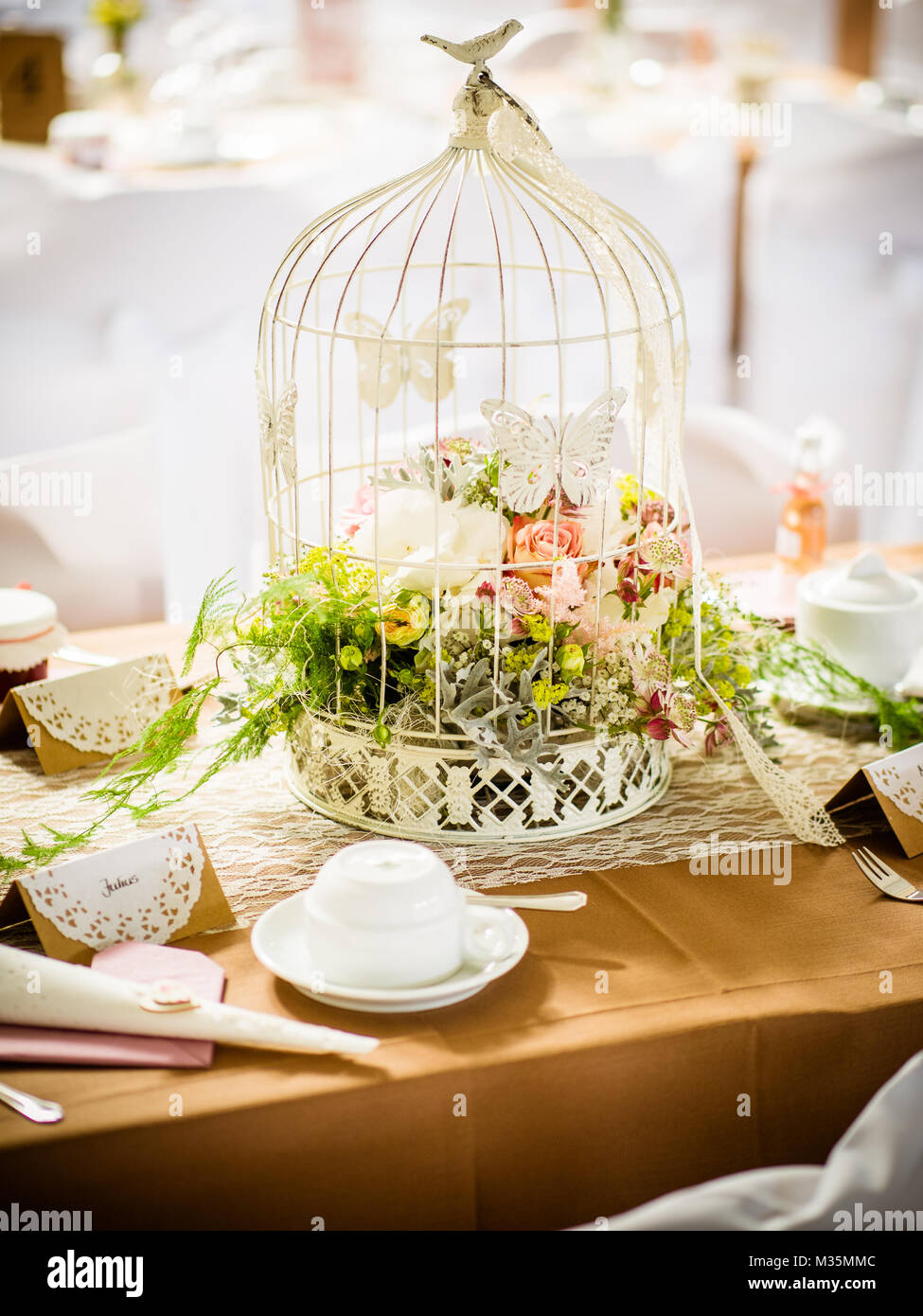 the table decoration for wedding, with roses and flowers in a birdcage, country house Stock Photo