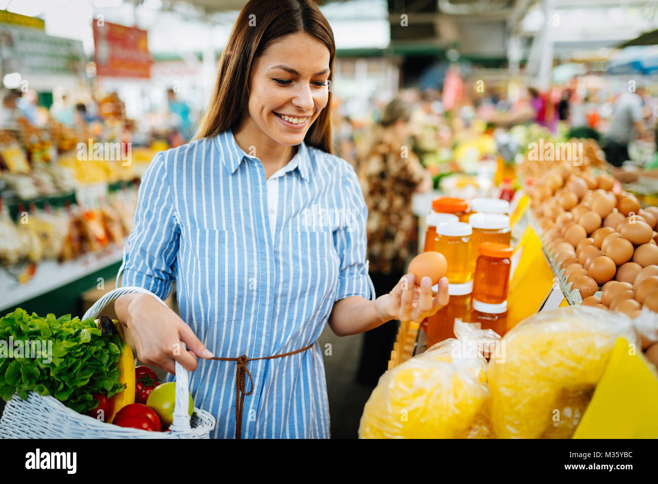 Portrait of beautiful woman holding shopping basket at marketplace Stock Photo