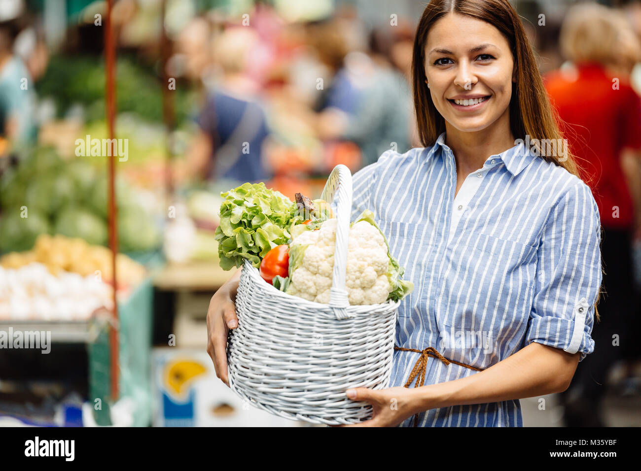 Portrait of beautiful woman holding shopping basket Stock Photo - Alamy