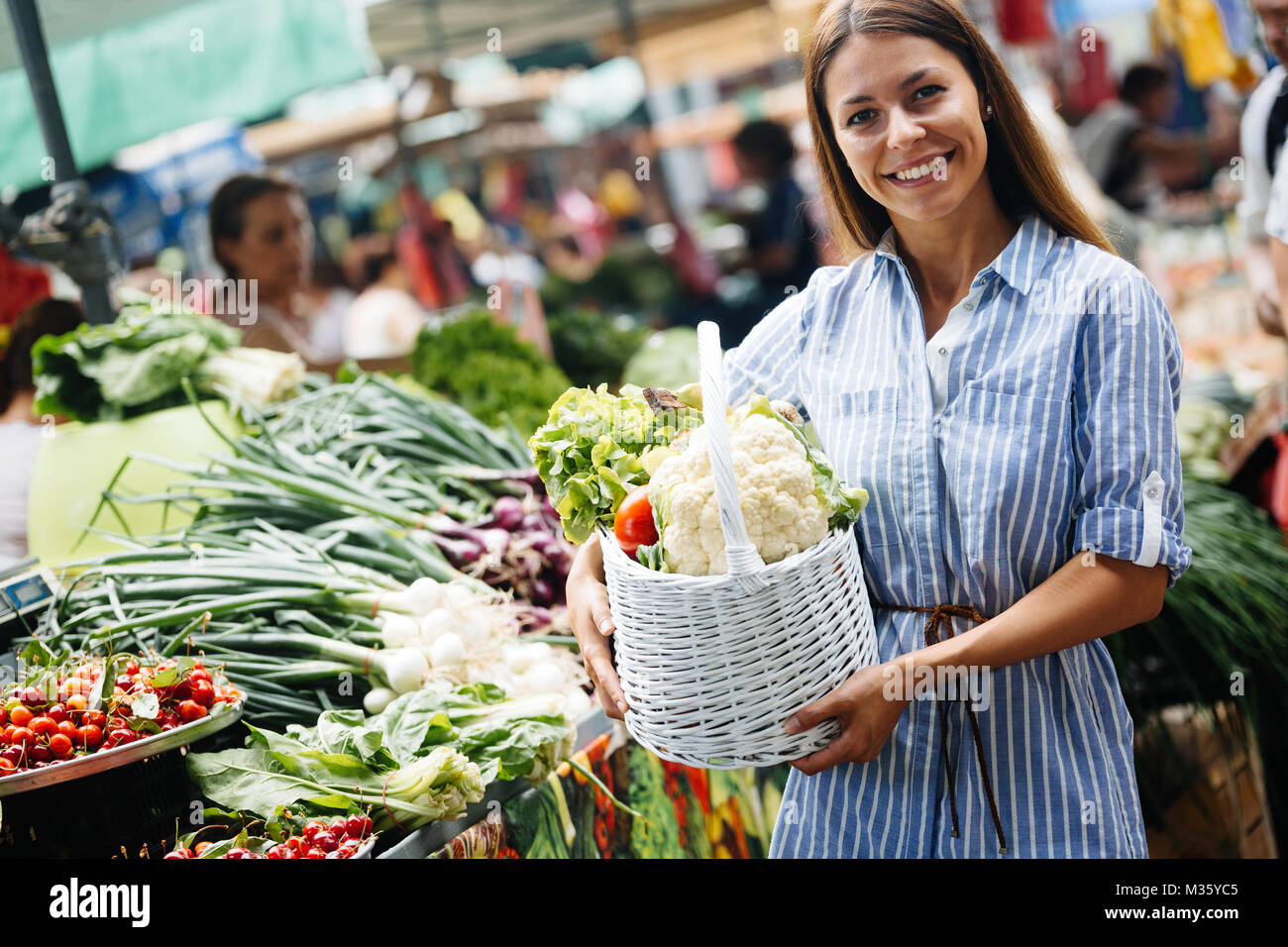 Portrait of beautiful woman holding shopping basket Stock Photo - Alamy