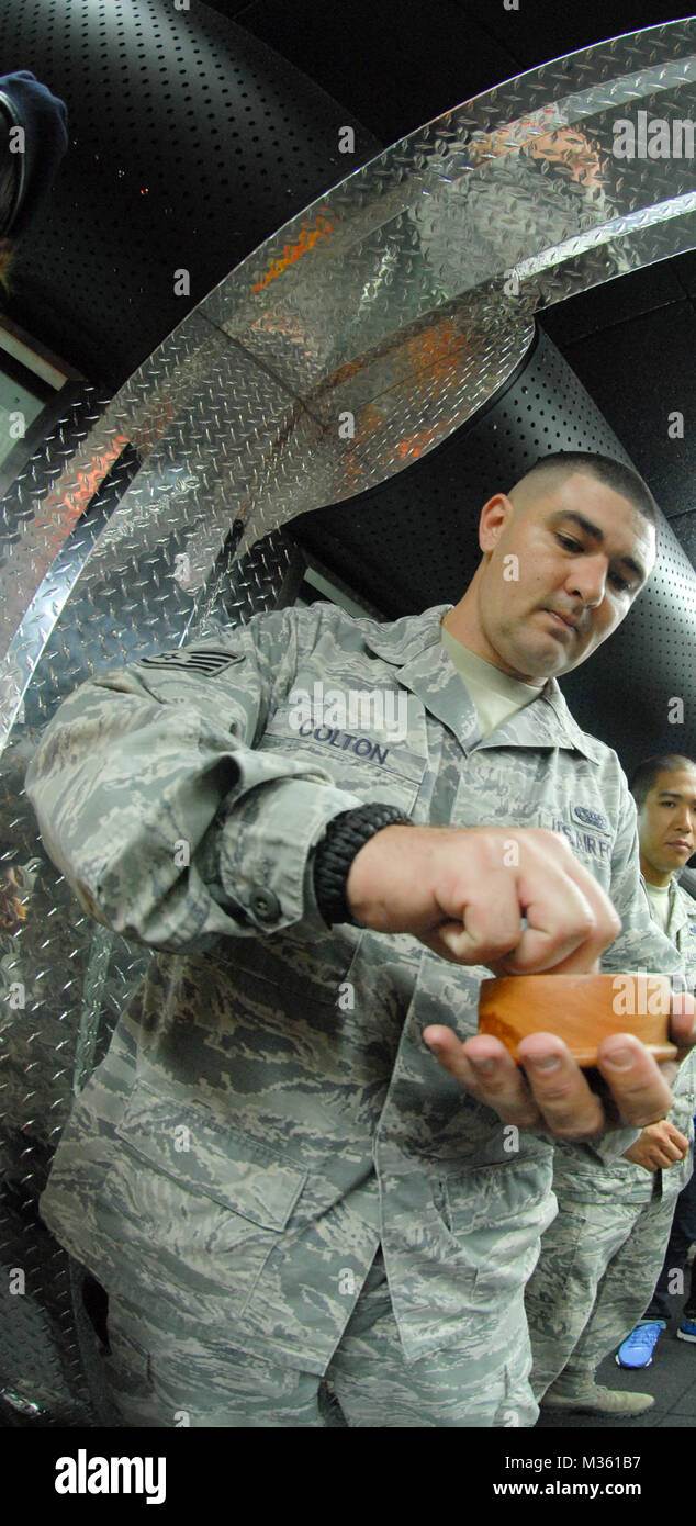 U.S. Air Force Staff Sgt Bronson Colton, 154th Security Forces Squadron (SFS), grabs a pinch of salt during the blessing ceremony of the 154th SFS Indoor Firing Range at Joint Base Pearl Harbor-Hickam, Hawaii, Aug. 8, 2015. Salt is spread throughout the facility by the Chaplain and members of the 154 SFS as a way to purify and protect the facility. (U.S. Air National Guard photo by Airman 1st Class Robert Cabuco) 150808-Z-UW413-008.JPG by Hawaii Air National Guard Stock Photo