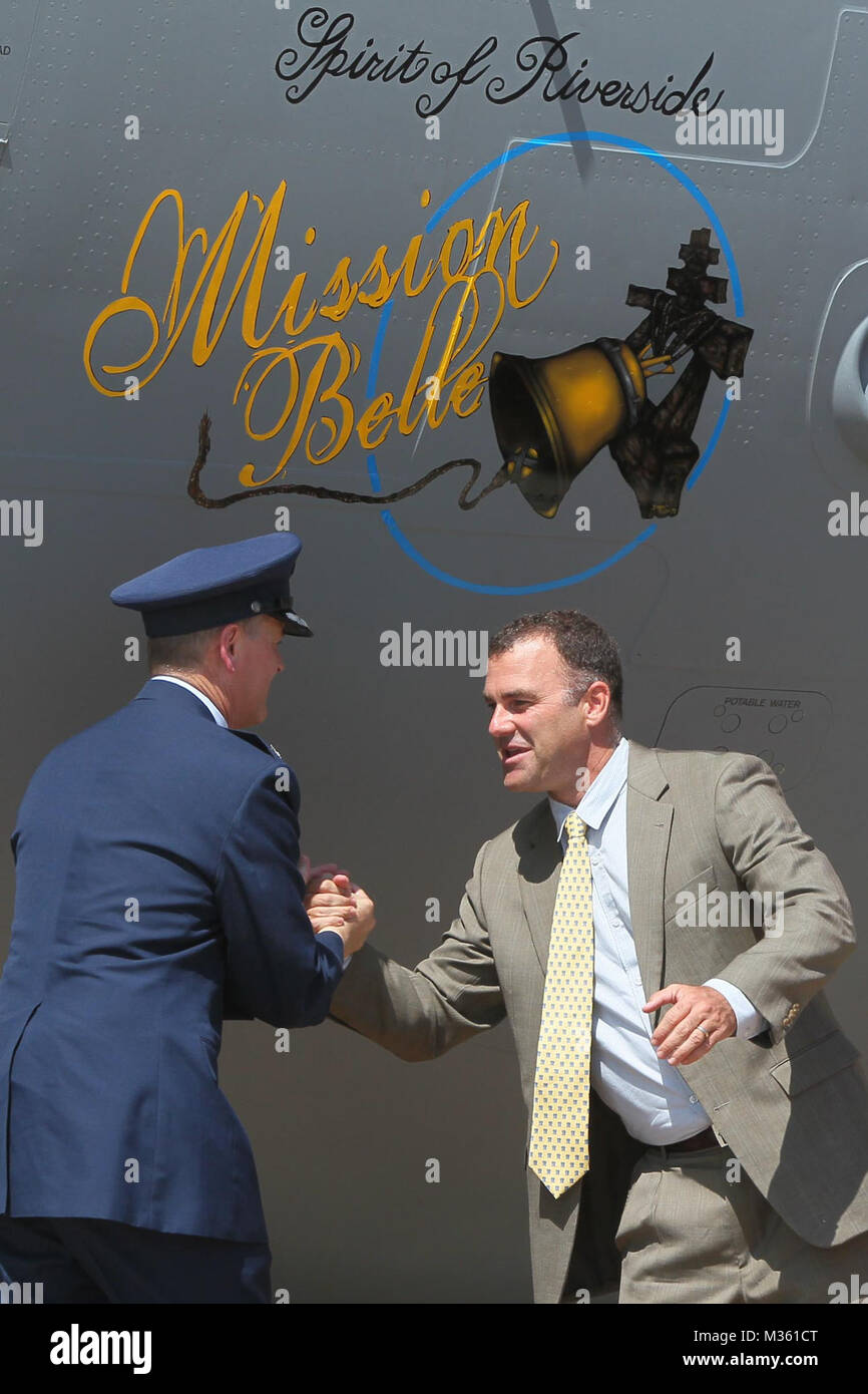 150811-N-HW977-330 MARCH AIR RESERVE BASE, Calif. (Aug. 11, 2015) Col. Russell Muncy, commander, 452nd Air Mobility Wing at March Air Reserve Base, left, and Rusty Bailey, mayor of Riverside, shake hands after unveiling new 'Mission Belle' C-17 nose art. Design was painted by Shayne Meder, a local aviation artist and Air Force veteran. Capt. Stephen H. Murray, Naval Surface Warfare Center (NSWC), Corona Division commanding officer, and his family attended the event. (U.S. Navy photo by Greg Vojtko/Released) 150811-N-HW977-330 by NAVSEA Corona Stock Photo