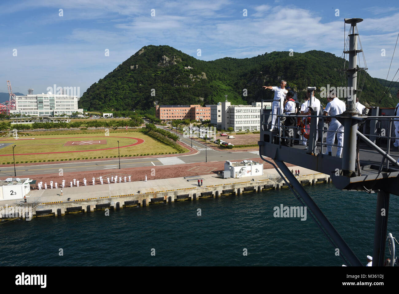 150813-N-NM917-175 BUSAN, Republic of Korea (Aug. 13, 2015) - Commanding Officer of the U.S. 7th Fleet flagship USS Blue Ridge (LCC 19), Capt. Kyle P. Higgins, right corner, observes the ship's arrival in Busan. Blue Ridge is currently providing support for U.S. 7th Fleet's involvement in the bi-lateral exercise, 2015 Ulchi Freedom Guardian (UFG). UFG is an annual, combined command and control exercise designed to enhance the combat readiness of ROK and U.S. supporting forces through joint training while improving ROK-U.S. relations. (U.S. Navy photo by Mass Communication Specialist 3rd Class  Stock Photo