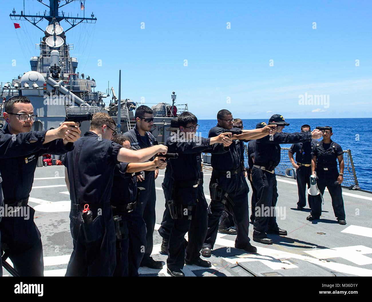 160620-N-YB832-080 PHILIPPINE SEA (June 20, 2016) Ð Sailors assigned to the guided-missile destroyer USS Curtis Wilbur (DDG 54), aim M9 Beretta pistols at their targets during a small-arms weapons qualification on the flight deck. Curtis Wilbur is on patrol with Carrier Strike Group Five (CSG 5) in the U.S. 7th Fleet area of responsibility supporting security and stability in the Indo-Asia-Pacific. (U.S. Navy photo by Mass Communication Specialist 3rd Class Ellen Hilkowski/Released) Sailors shoot pistols while at sea to keep shooting skills sharp by #PACOM Stock Photo