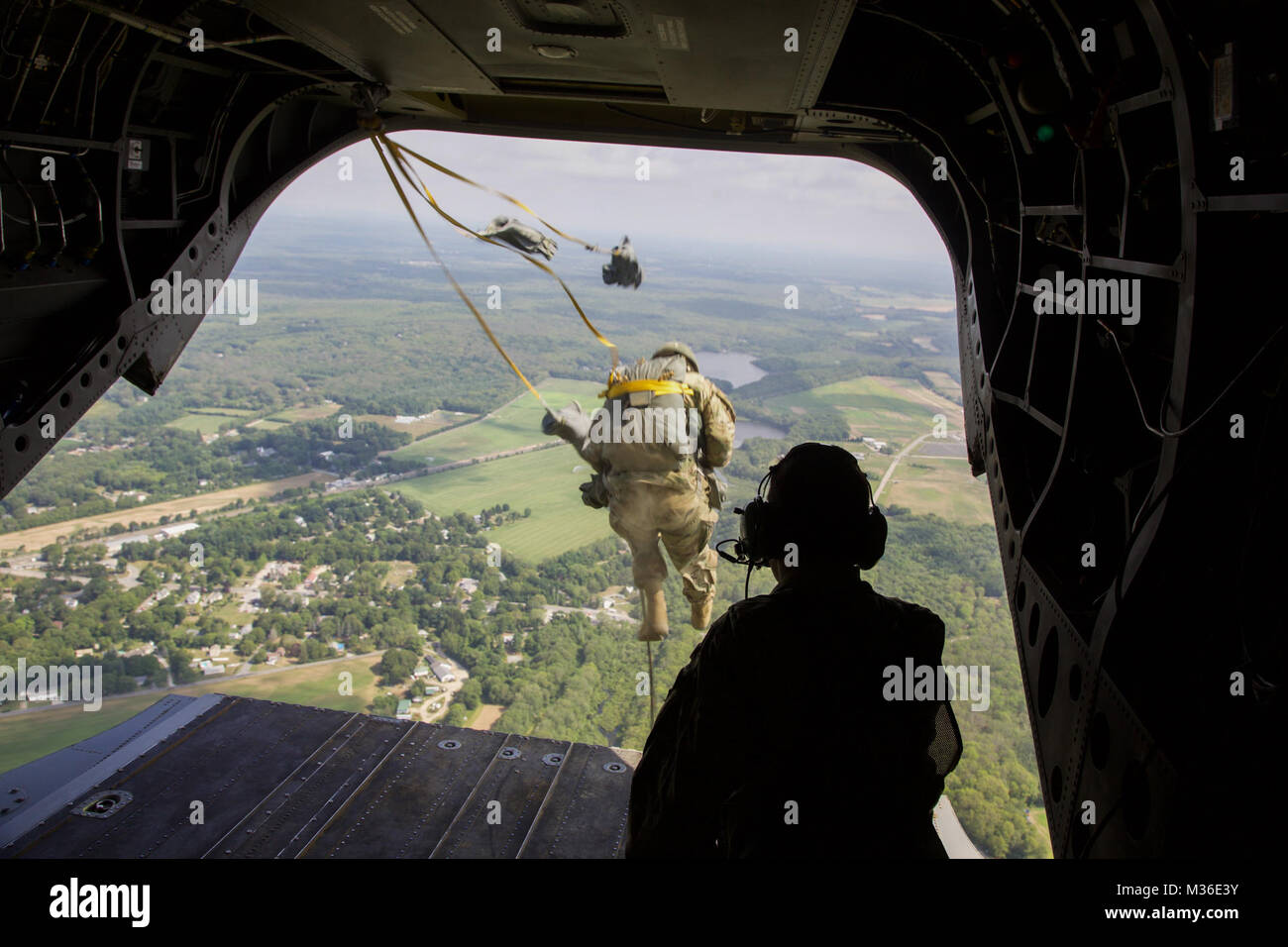 A U.S. Army Paratrooper jumps from a CH-47 F Chinook Helicopter during Leapfest 2016 at the University of Rhode Island, West Kingston, R.I., August 6, 2016. Leapfest is the largest, longest standing, international static line parachute training event and competition hosted by the 56th Troop Command, Rhode Island Army National Guard to promote high level technical training and esprit de corps within the International Airborne community. (U.S. Army photo by Sgt. Austin Berner/Released) Leapfest 2016 by The National Guard Stock Photo