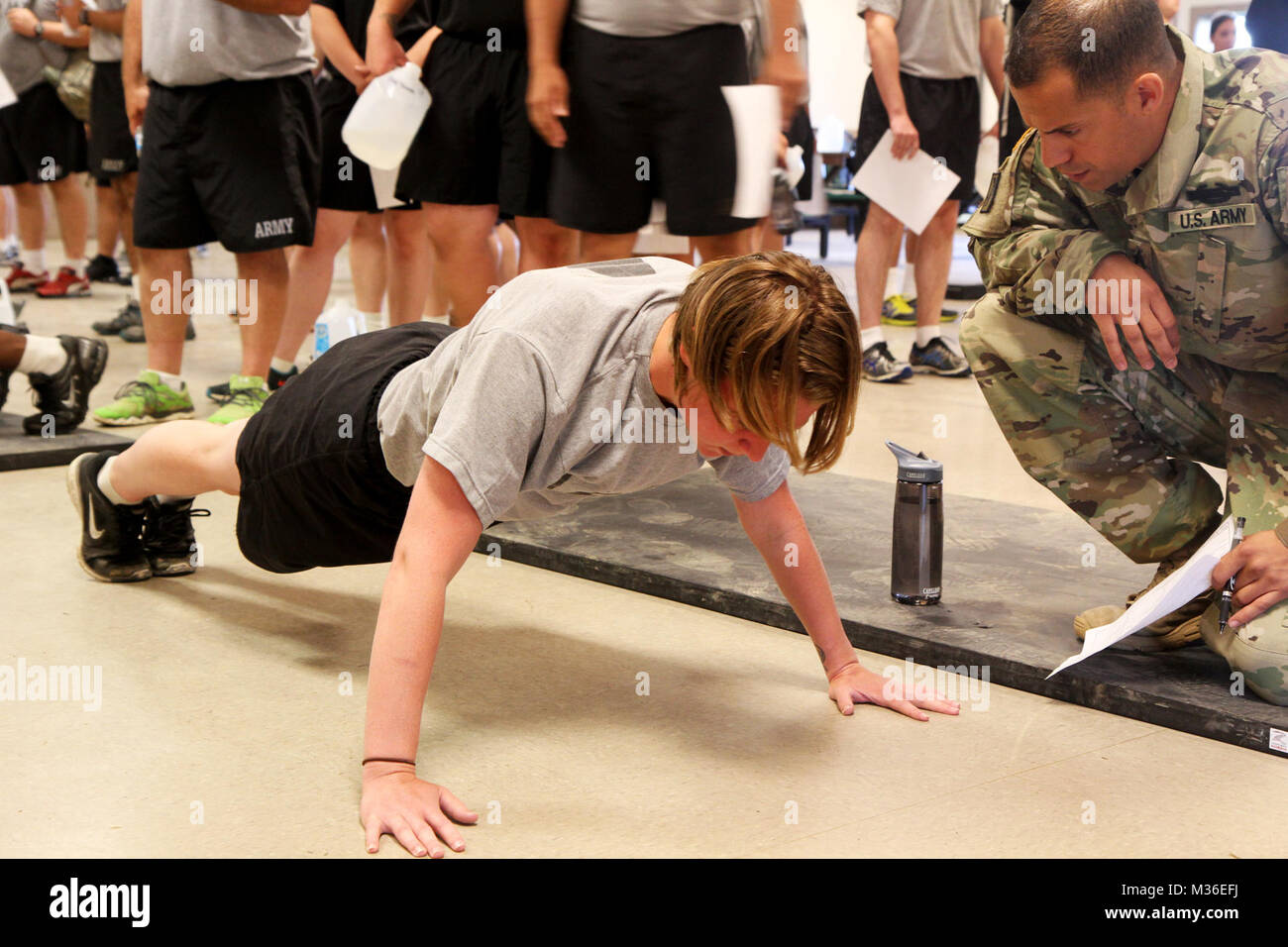 FT. INDIANTOWN GAP, PA- Army Spc. Katelyn Loveland, assigned to the 2nd Squadron, 104th Cavalry, 56th Brigade, 28th Infantry Division, a participant in the Fitness Improvement Training Program Plus (FIT-P+) and a native of Baltimore, Md., performs push ups during an Army Physical Fitness Test while her grader, Sgt. 1st Class Victor Arocho observes Aug. 19, 2016. Loveland said she enjoyed learning about the areas in her lifestyle that needed healthy changes, such as calorie intake portion control. (U.S. Army National Guard photo by Sgt. 1st Class HollyAnn Nicom, 109th Mobile Public Affairs Deta Stock Photo
