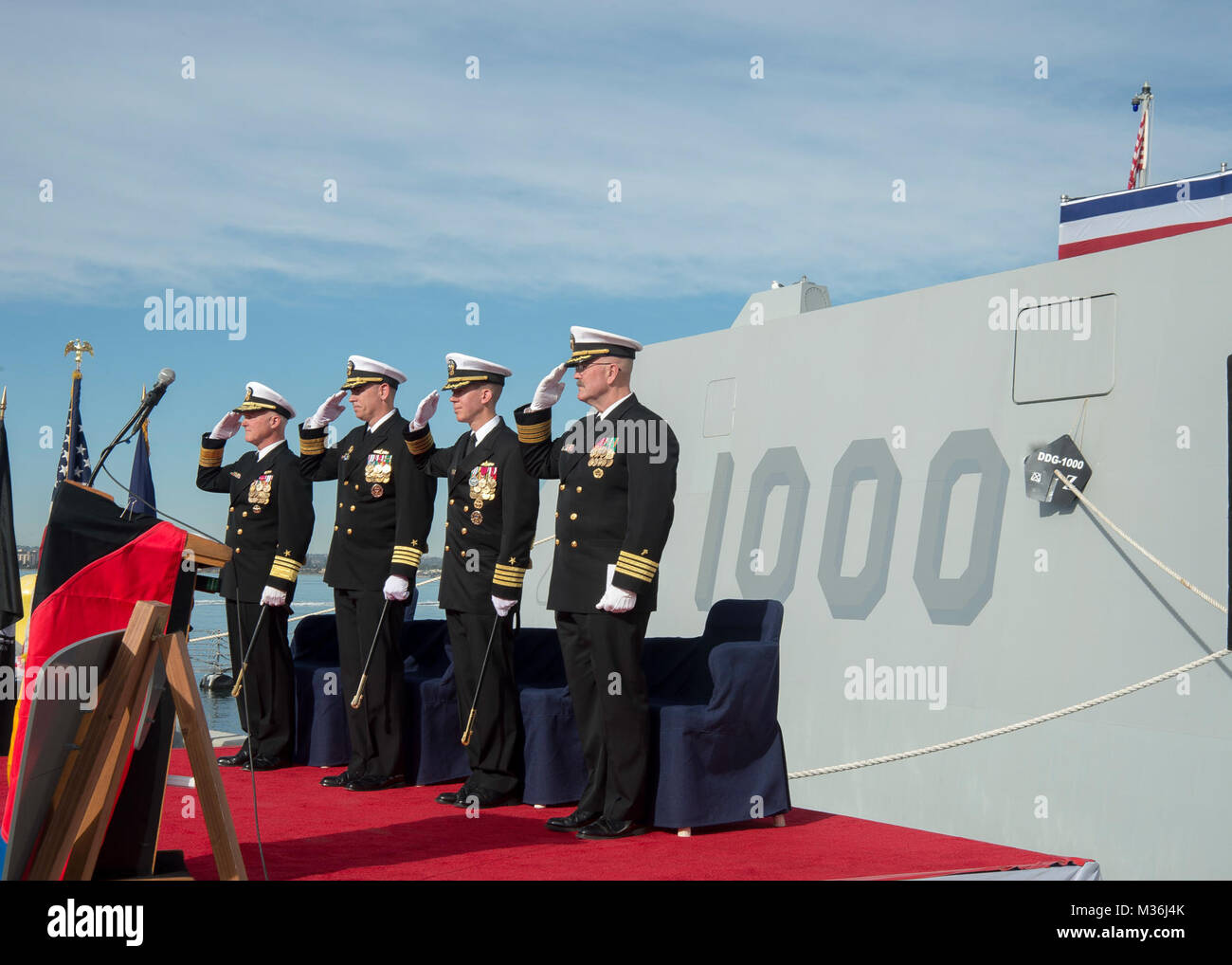 SAN DIEGO (Dec. 20, 2016) Left to right, Vice Adm. Thomas Rowden, commander, Naval Surface Forces, Capt. James A. Kirk, outgoing commanding officer (CO) of  guided-missile destroyer USS Zumwalt (DDG 1000), Capt. Scott A. Tait, in-coming CO of Zumwalt, and Capt. W. Kyle Fauntleroy, Force Chaplain, Surface Force, U.S. Pacific Fleet, salute the ensign during a change of command ceremony at Naval Base San Diego. (U.S. Navy photo by Petty Officer 2nd Class Zachary Bell/Released) USS Zumwalt Holds Change of Command Ceremony by #PACOM Stock Photo