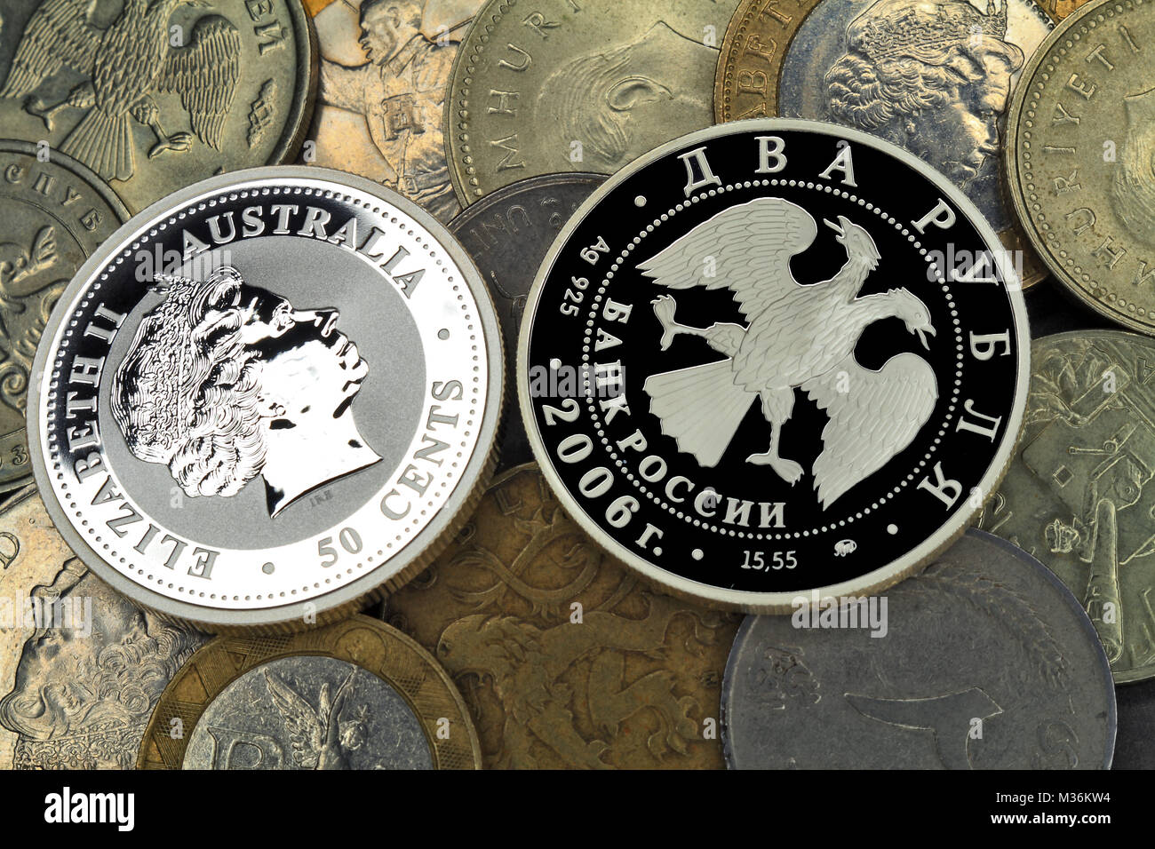 New silver coins on a background of usual old coins of the various countries Stock Photo