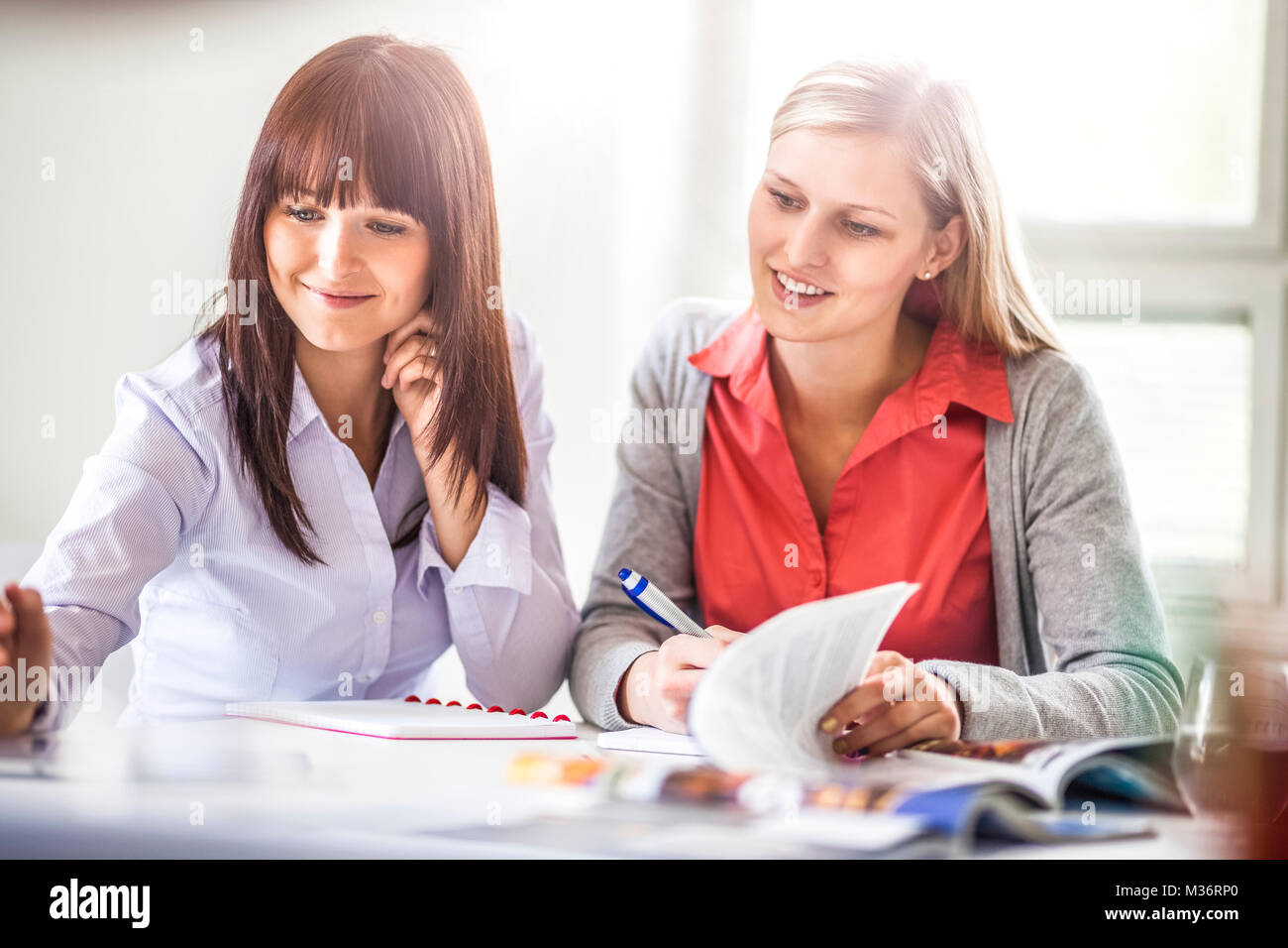 Young businesswomen working together at desk in office Stock Photo - Alamy