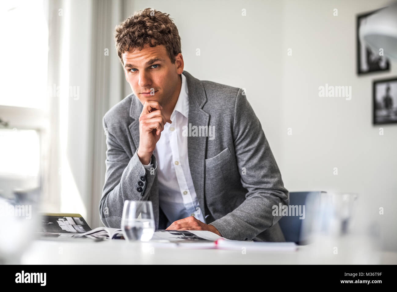 Portrait of confident young businessman working at office table Stock ...