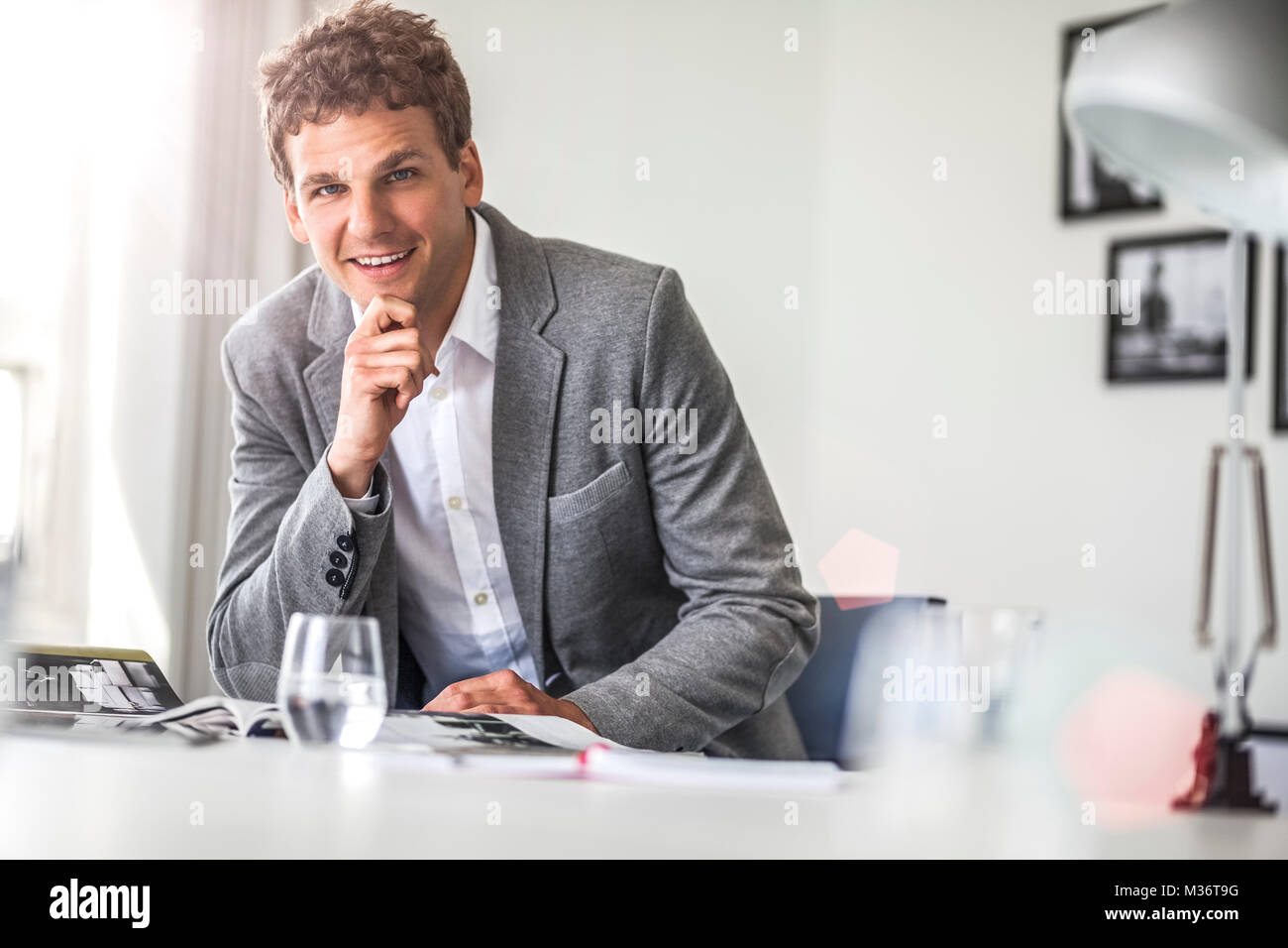 Portrait of confident young businessman working at office table Stock ...