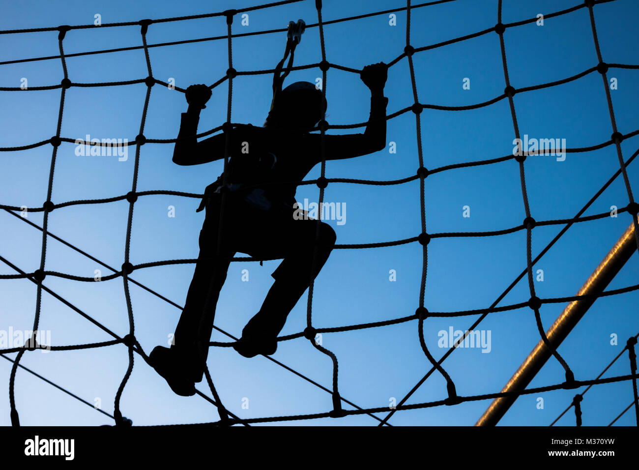 Person climbing on high ropes Stock Photo - Alamy
