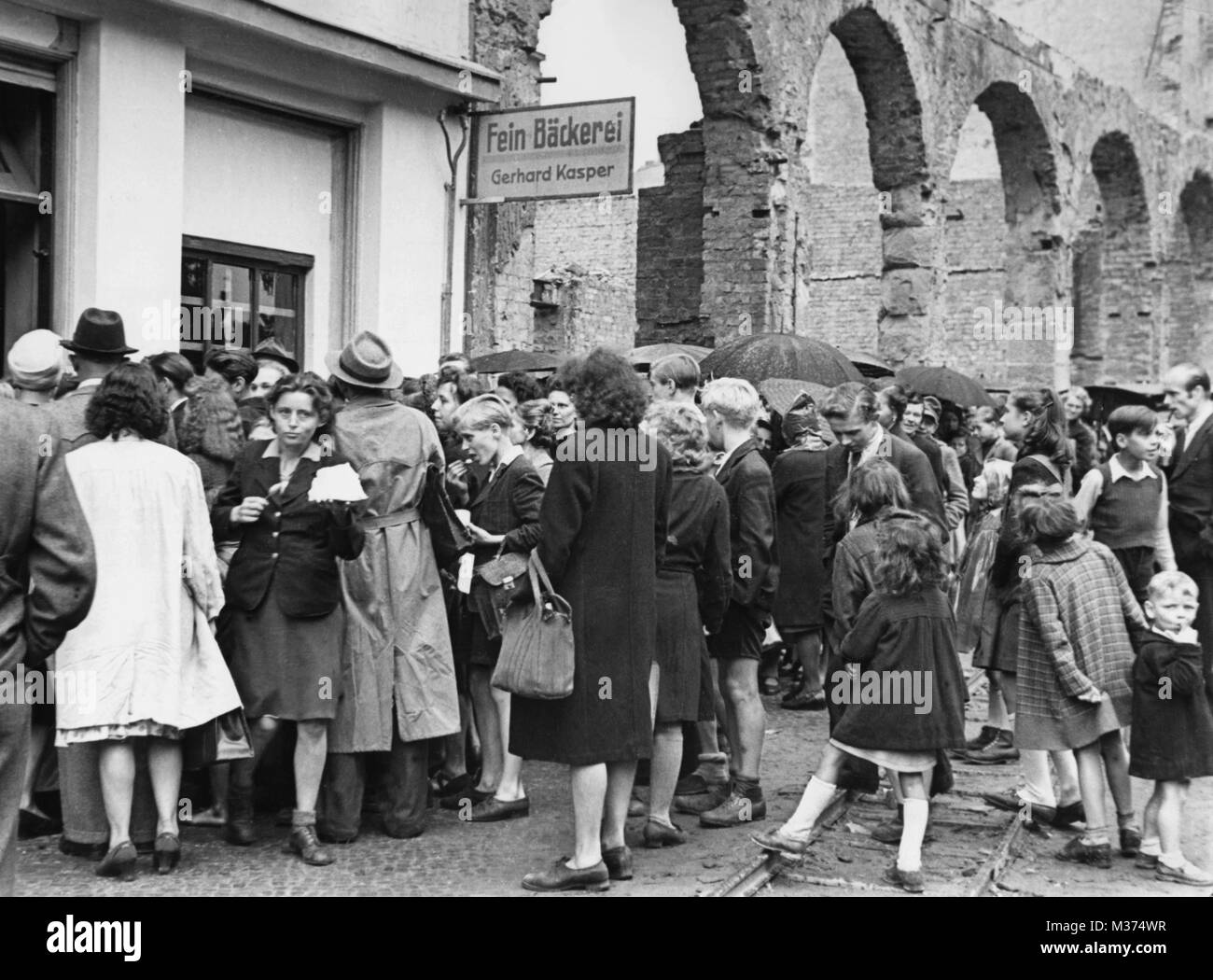 People staying on line in front of a shop on 23 June 1948 that sells creme for 'old money'. The new Deutsche Mark in an issuing office in Frankfurt am Main. The currency reform in the western part of Germany came into force on 21 June 1948. | usage worldwide Stock Photo