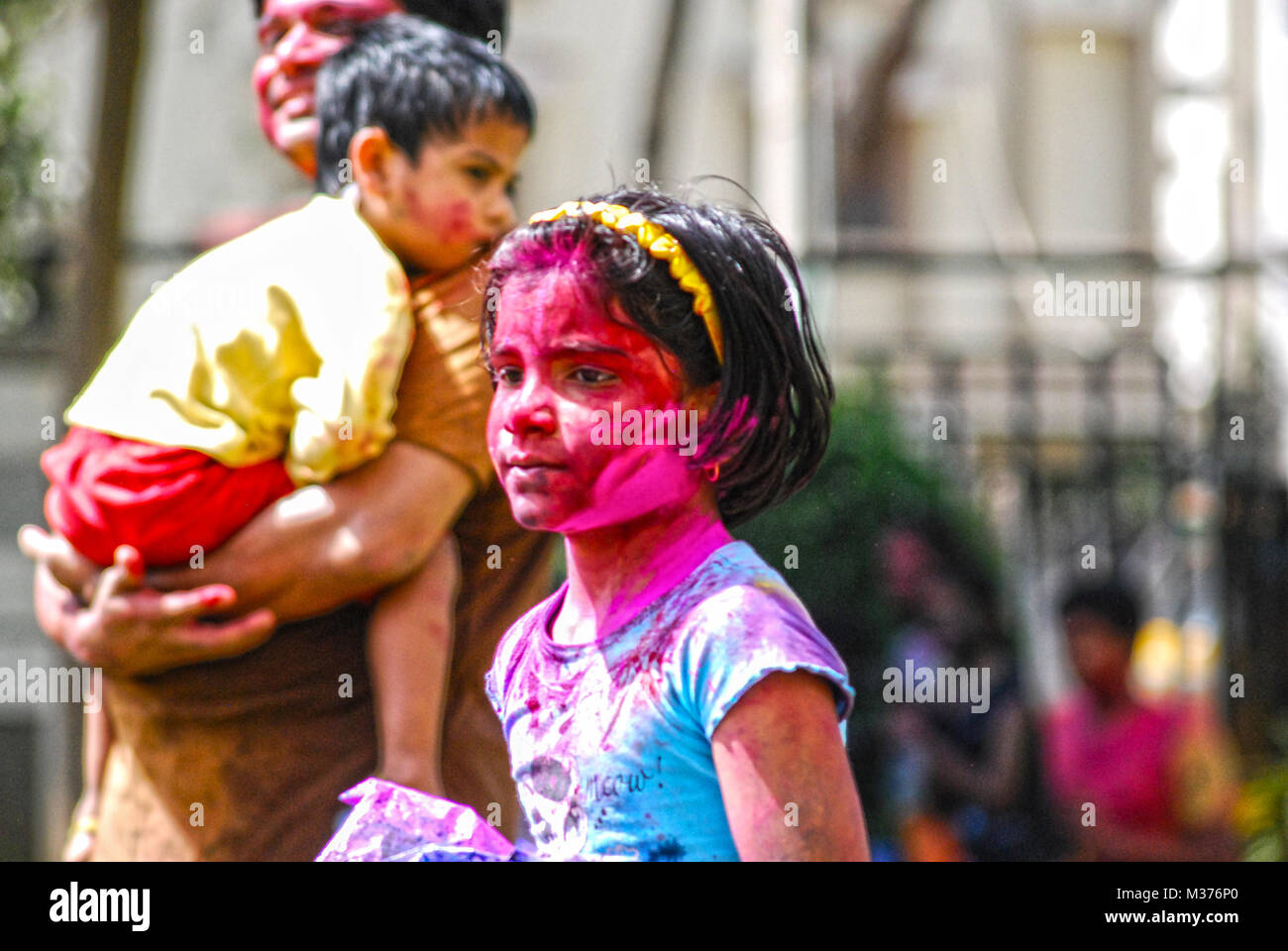 A young girl is covered in powder paint during the celebration of Holi in Hyderabad, India. Stock Photo