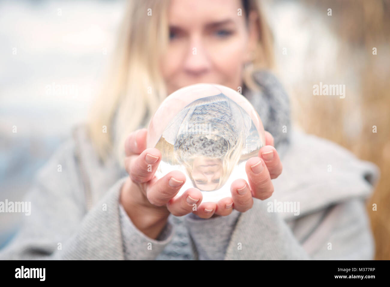 Woman holding up crystal ball hi-res stock photography and images - Alamy