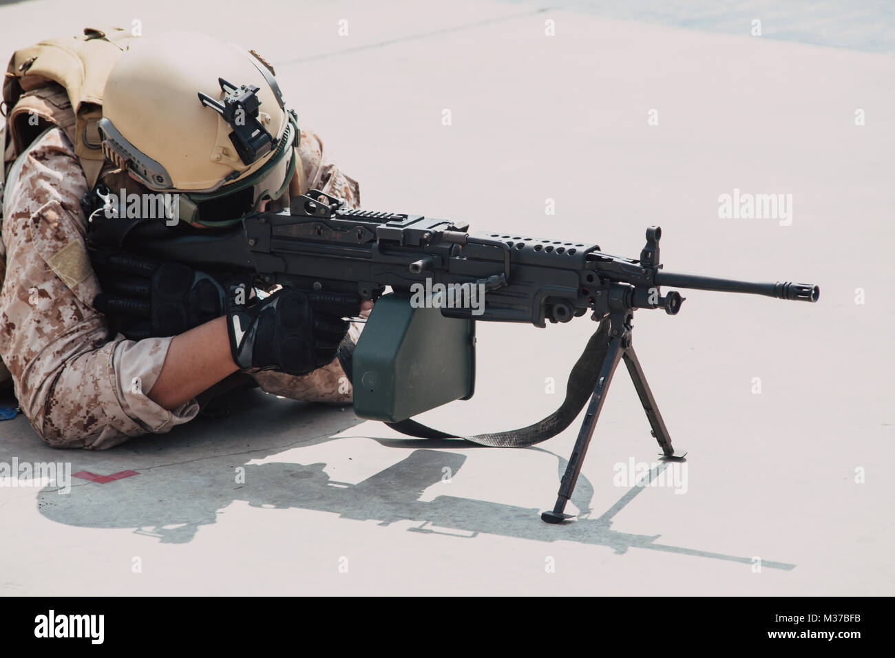 military army soldier lies prone on a firing Machine Gun M249 closeup Stock Photo
