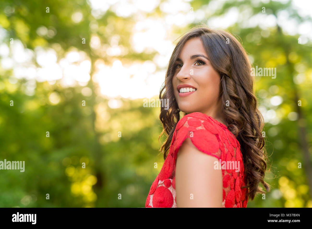 Portrait of young beautiful woman in red dress posing in the park Stock ...