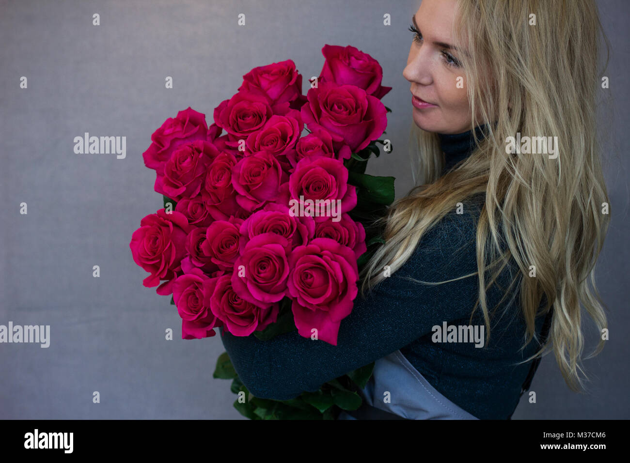 Beautiful young woman holding big bouquet of pink roses Stock Photo - Alamy