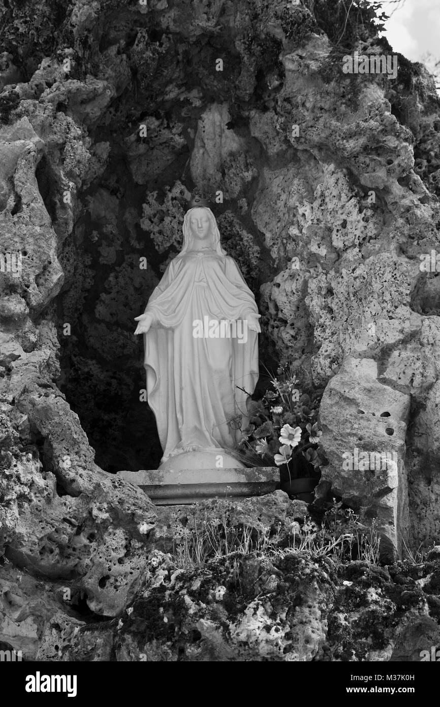Statue of Our Lady of Lourdes in the Grotto in the grounds of Château de Sully in the Loire Valley, France Stock Photo