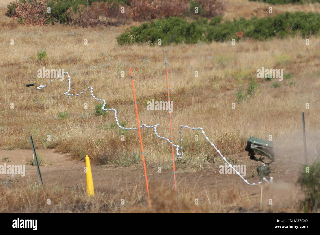 170503-N-HW977-249 CAMP PENDLETON, Calif. (May 3, 2017) An Anti-Personnel Obstacle Breaching System (APOBS) is deployed during a test and evaluation. APOBS is a length of detonating cord with attached grenades that is carried over an obstacle or minefield by a rocket to clear a safe path. NSWC Corona personnel collected data, while Marines from 1st Combat Engineer Battalion, Camp Pendleton, Calif., and Navy Explosive Ordnance Disposal technicians, based in San Diego, Calif., provided critical support in preparing and executing the system. (U.S. Navy photo by Greg Vojtko/Released) 170503-N-HW97 Stock Photo