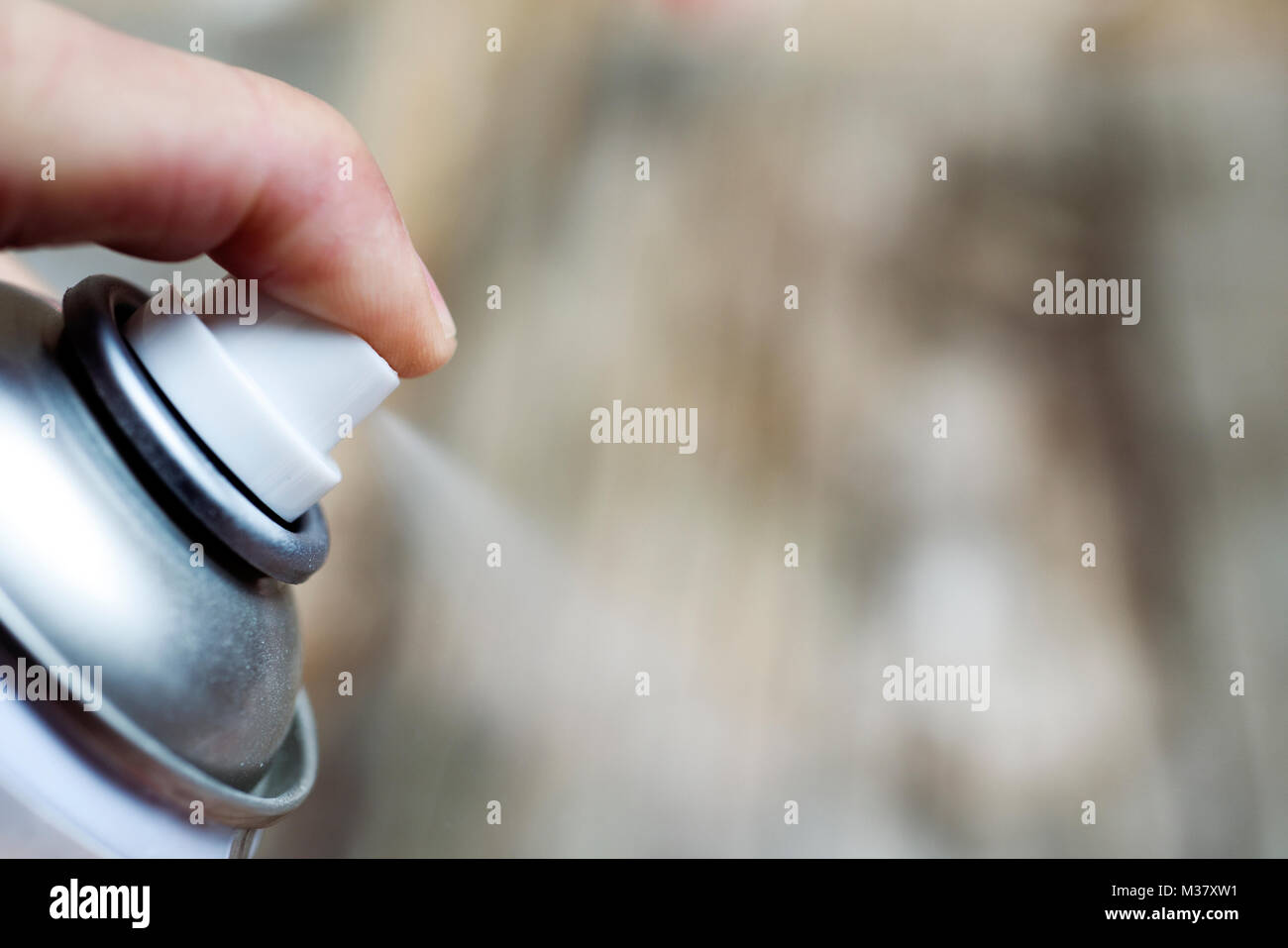 closeup of a young caucasian man spraying the product of an aerosol can Stock Photo