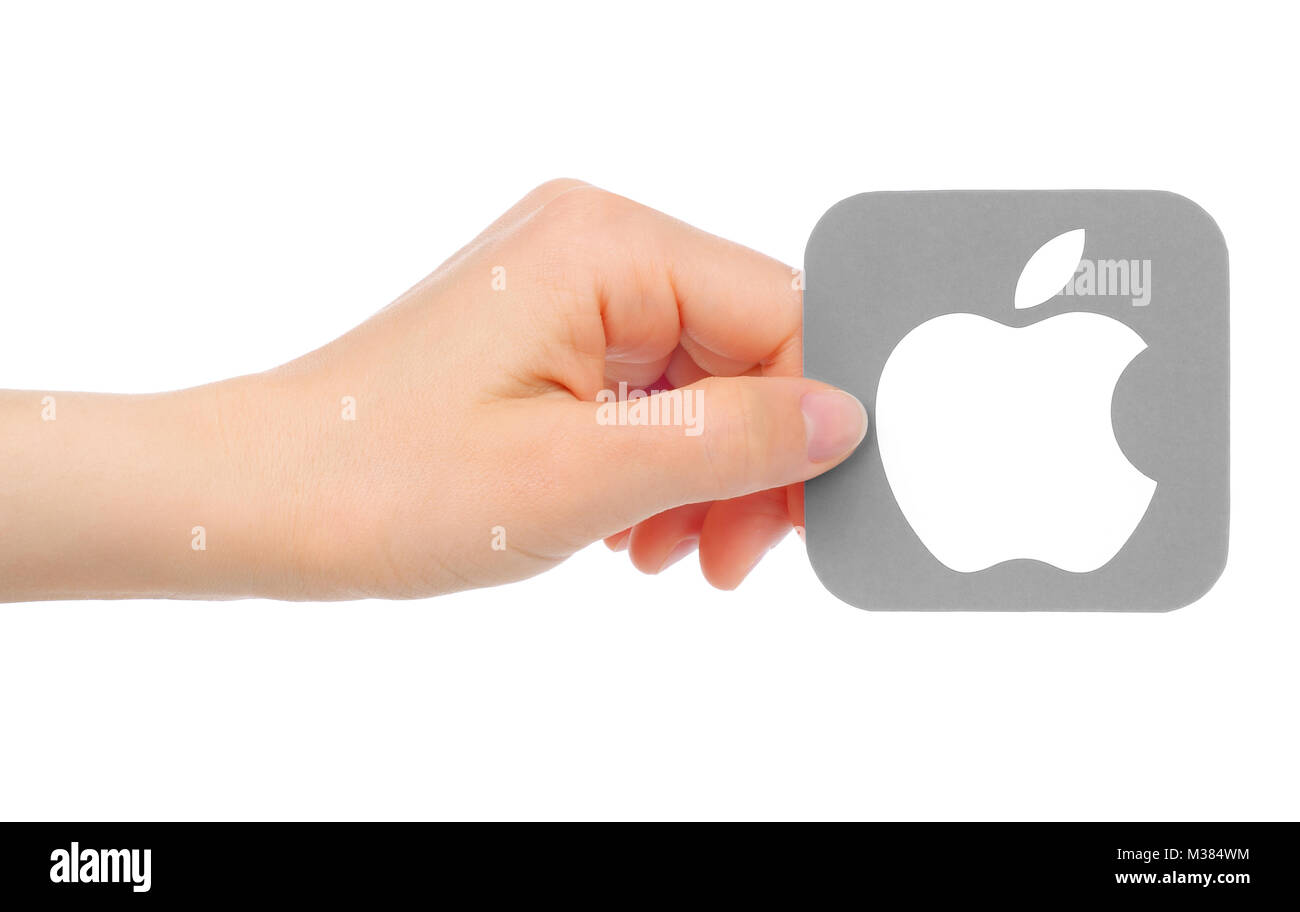 Kiev, Ukraine - May 18, 2016: Hand holds Apple icon printed on paper. Apple is an American multinational technology company Stock Photo