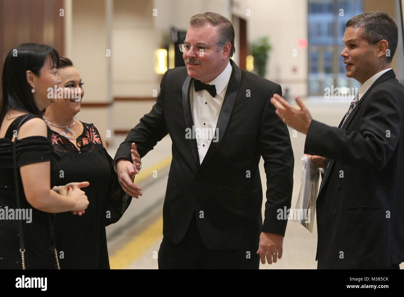 171014-N-HW977-075 RIVERSIDE, Calif. (Oct. 14, 2017) Alice Luh, left, Renee Schumacher, Richard Schumacher, Measurement Science and Engineering Department head, and Peter Solis greet one another on arrival during the 2017 Inland Empire Navy Birthday Ball. The sold-out event, commemorating the U.S. Navy's 242nd birthday, included dinner, ceremonies, music and dancing and featured a keynote address by Capt. Stephen H. Murray, Naval Surface Warfare Center (NSWC) chief engineer. All proceeds to benefit the Navy-Marine Corps Relief Society. (U.S. Navy photo by Greg Vojtko/Released) 171014-N-HW977-0 Stock Photo