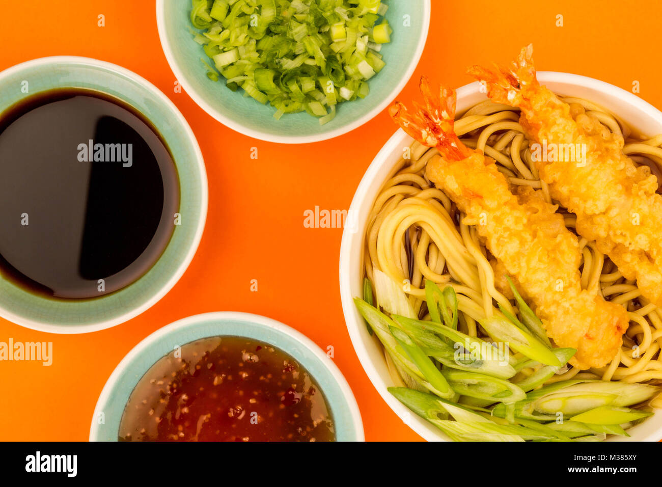 Japanese Style Tiger Prawn Tempura Noodle Soup With Spring Onions Against An Orange Background Stock Photo