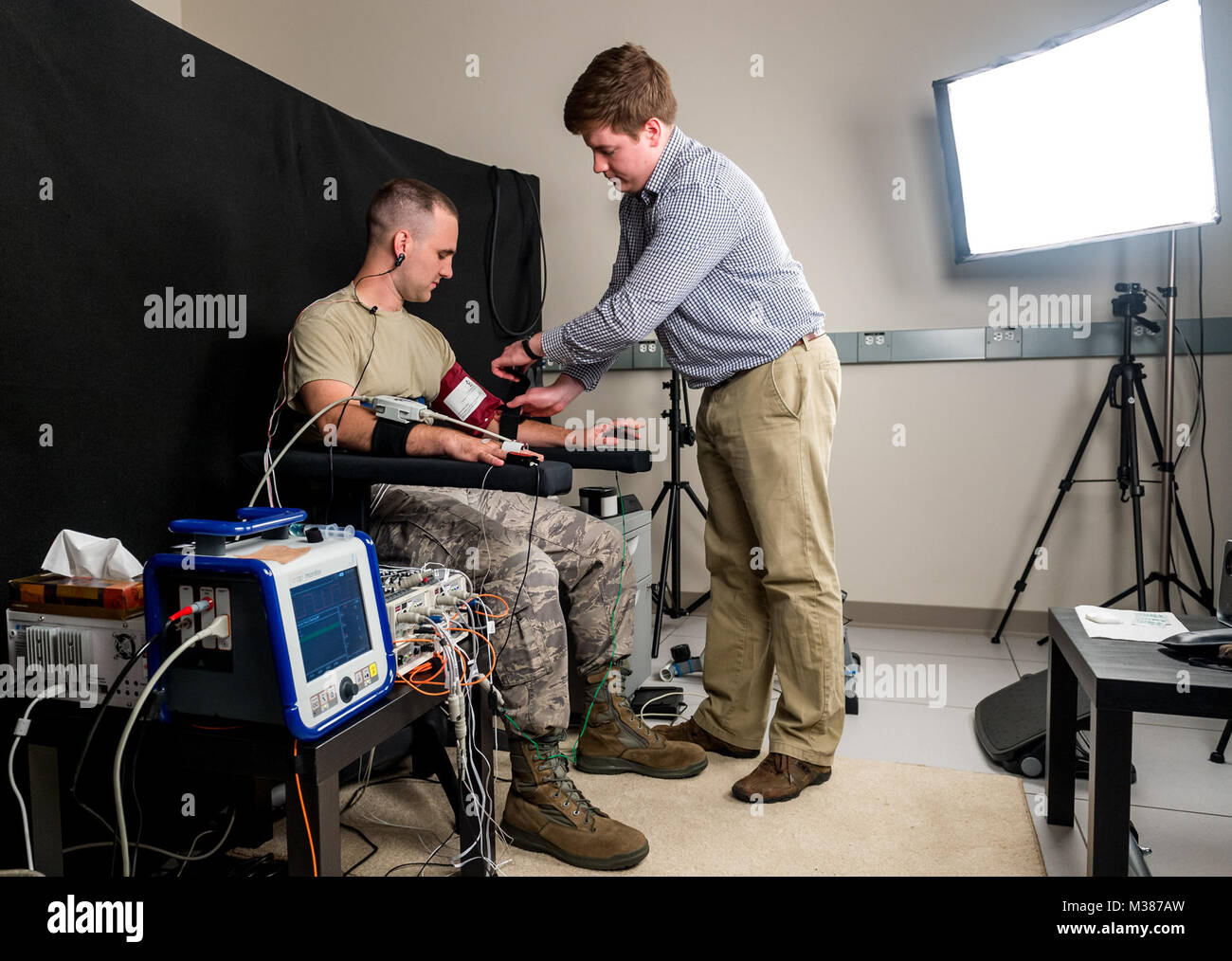Biomedical engineer Ethan Blackford attaches sensors test subject Staff