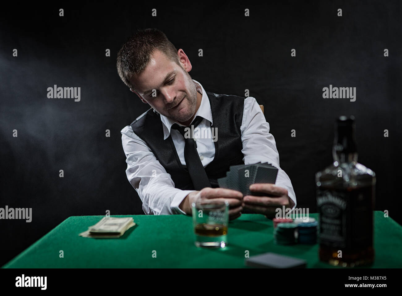 Tough guy playing his poker cards close to his chest at the poker table