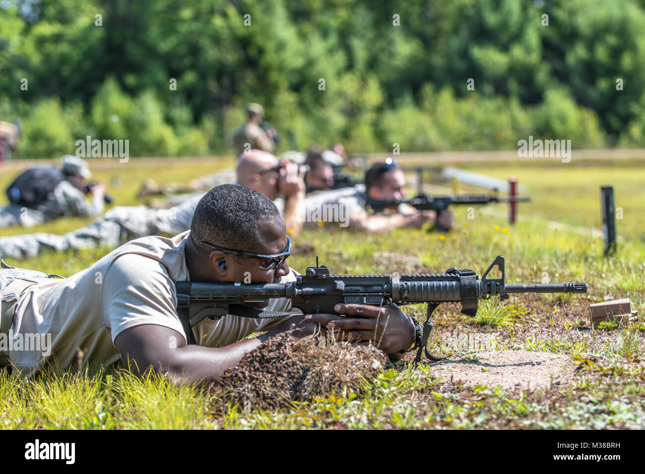 Sgt. Tookie Gregoire of the 251st Engineer Company (Sapper) fires his M4 Carbine downrange at Canadian Forces Base Gagetown in New Brunswick, Canada on August 14th, 2017. The stress shoot combined long distance target engagement with physically fatiguing tasks all while being timed. Starting at 600 meters, the Soldiers we’re required to fire quickly at their targets and then sprint 100 meters to the next firing positioning while being verbally motivated by their instructors. They would repeat this process until they reached the 100 meter firing position. 170814-Z-JY390-16 by Maine Army Nationa Stock Photo