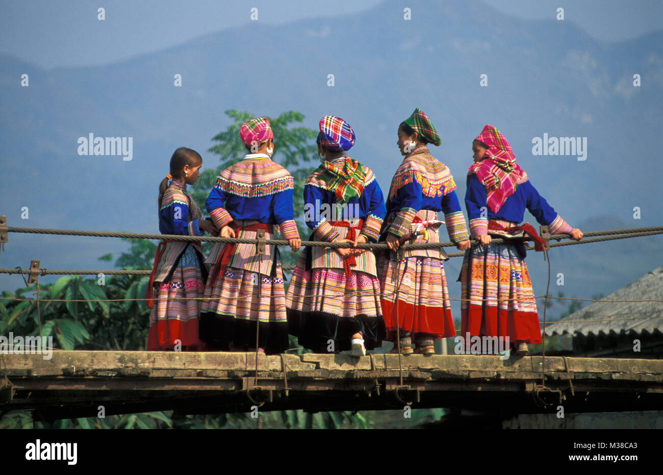 Vietnam. Bac Ha. Flower Hmong hilltribe. Women on suspension  bridge. Stock Photo