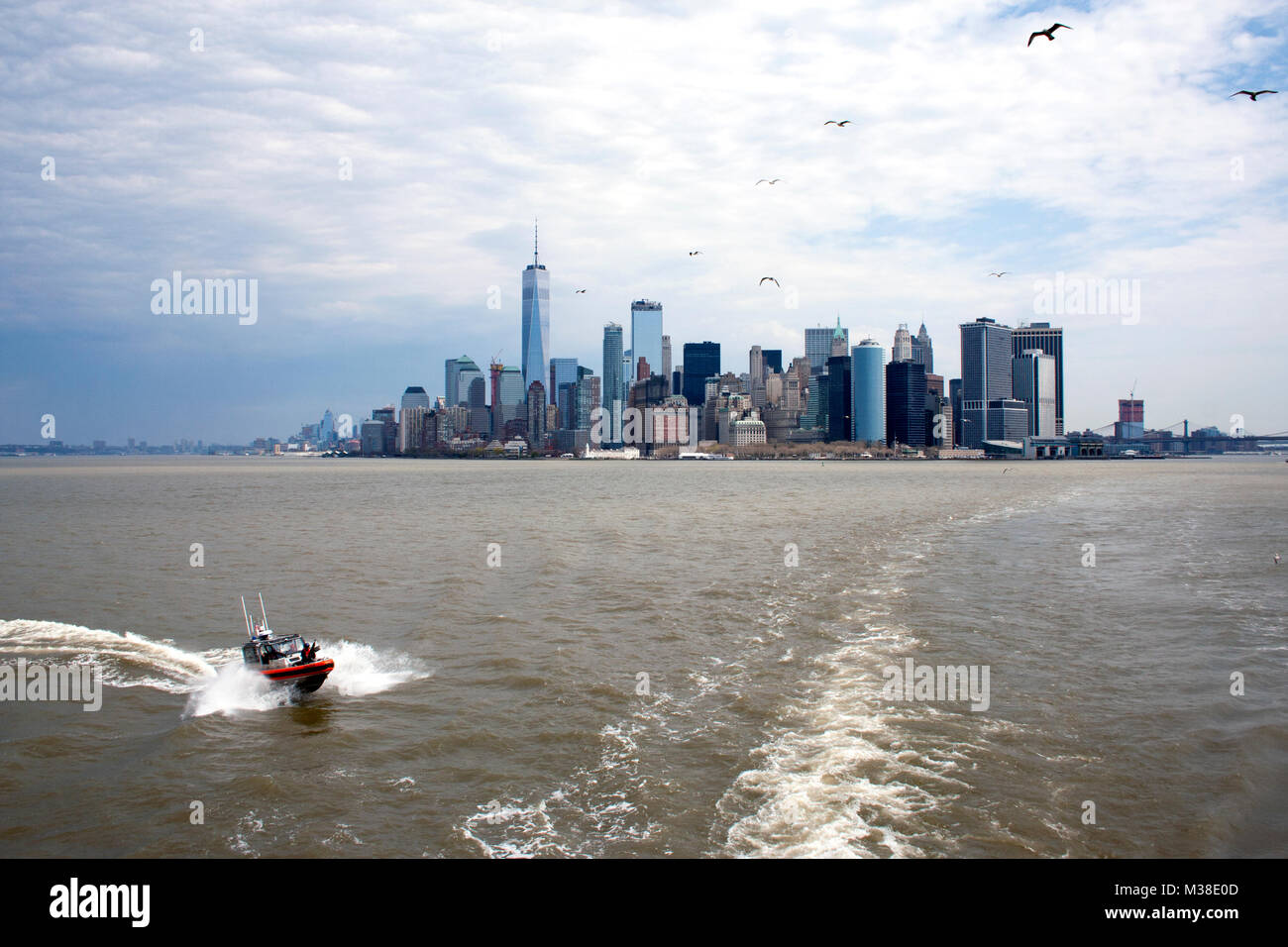 Coast Guard escort follows the State Island Ferry, with a view of Manhattan Stock Photo